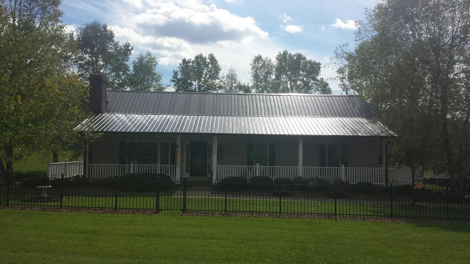 Gray metal roof on a brick ranch with a full width front porch — Gutter Guard Installation work by our crew in Gap