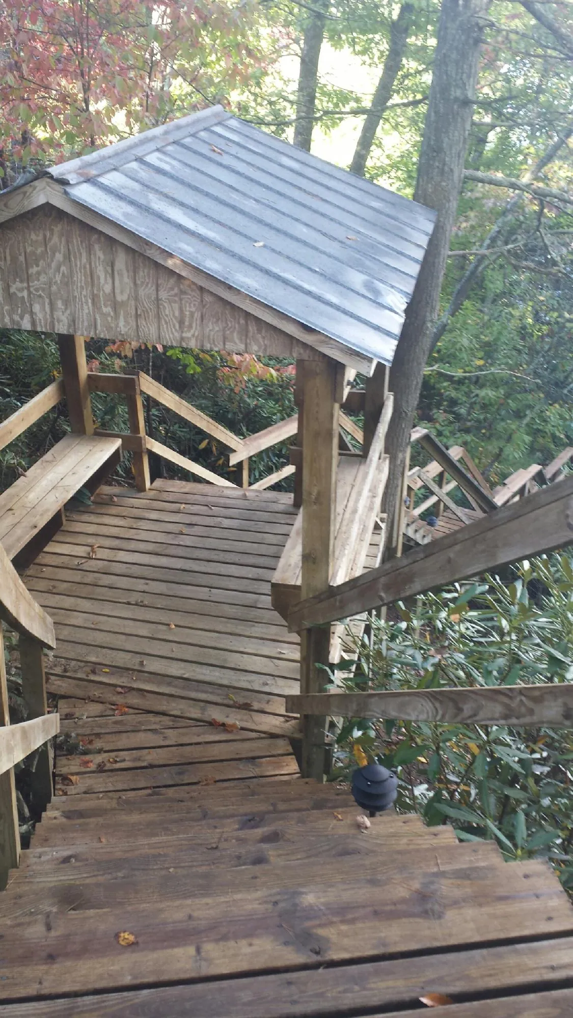 Metal roofed shelter over wooden steps on a wooded walkway — Skylight Repair & Installation work by our crew in Gap