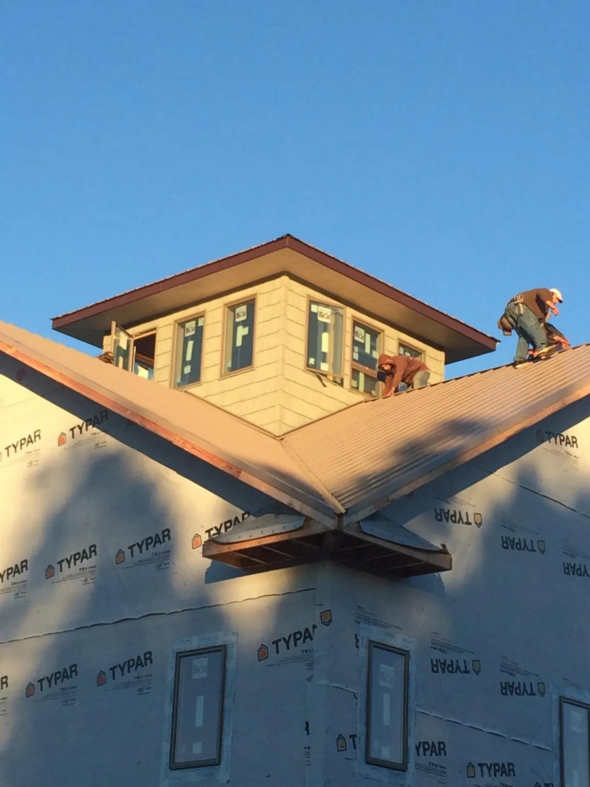 Roofers working around a rooftop cupola on a new metal roof at sunset — Roof Waterproofing in Gap by Roofing Brothers